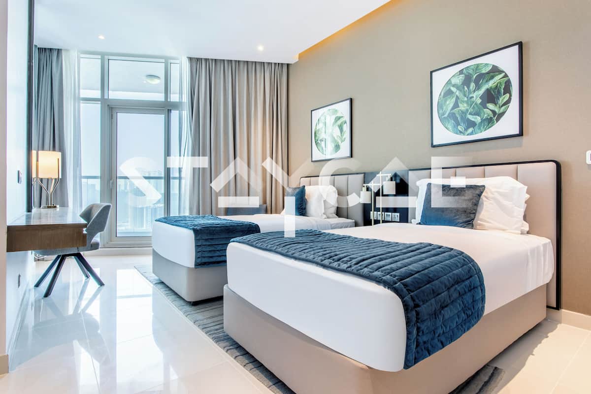 A modern hotel room with two beds, a desk, and a large window with curtains.