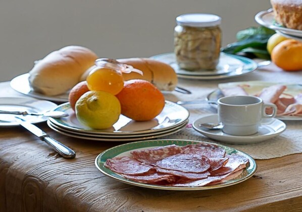 Disposição para o café da manhã com pratos de comida, uma xícara e um pote.