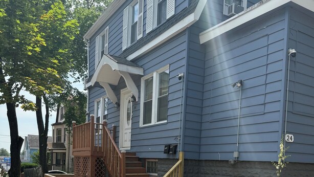 A two-story house with a front porch, a staircase, and a mailbox.