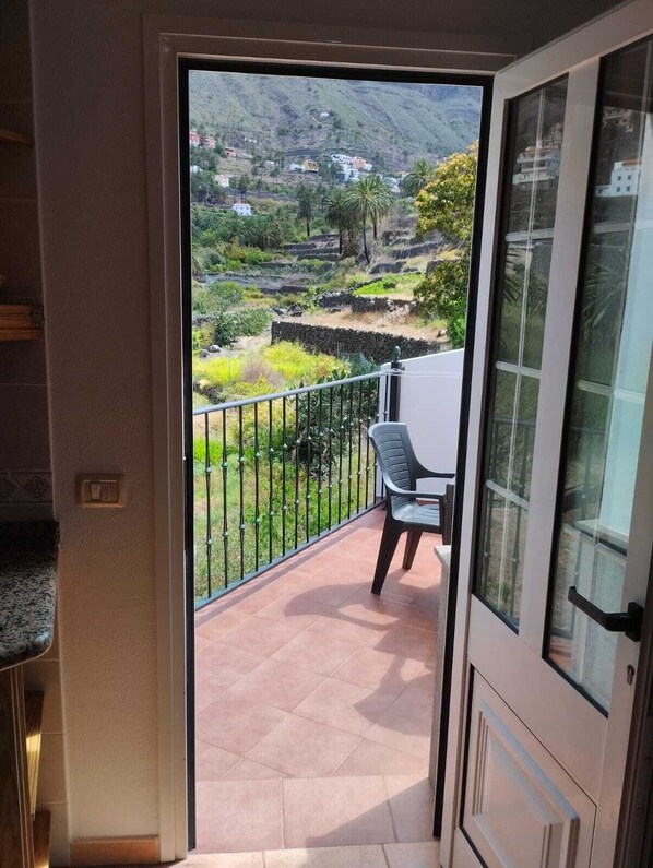 A balcony with a view of terraced fields and a mountain.