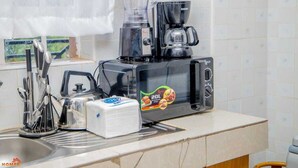 A kitchen with a coffee maker, blender, and a box of paper towels on the counter. - Lux Suites Truna Executive Homes Kisii (Kisii)