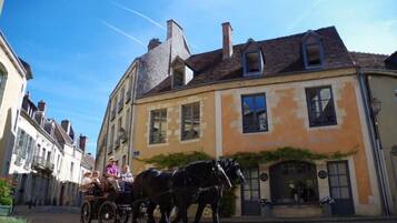 A horse-drawn carriage in a narrow street with buildings on either side.