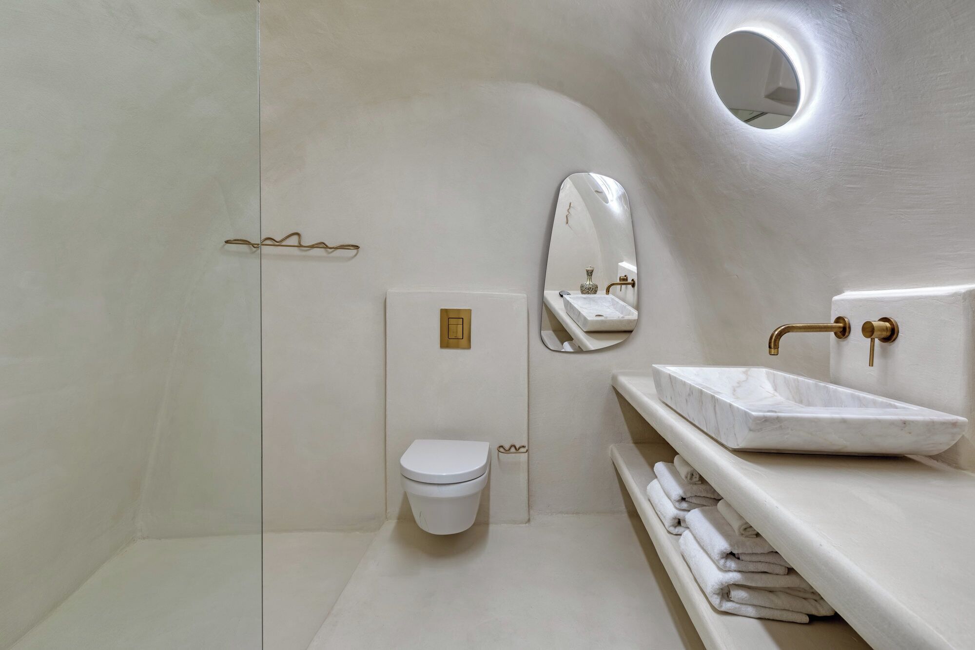 A modern bathroom with a toilet, sink, and shower area.