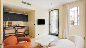 Un espacio habitable compacto con cocina, comedor y sala de estar con sofá y sillones.