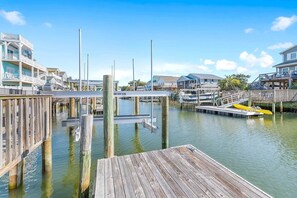 A waterfront dock with wooden pilings, a pier, and a small boat.