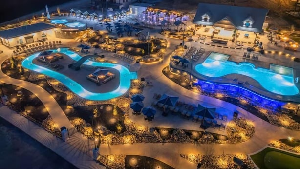 A resort with multiple swimming pools, outdoor seating areas, and a variety of buildings.