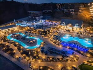 Ein Resort mit mehreren Schwimmbecken, Außenbereichen zum Sitzen und verschiedenen Gebäuden.