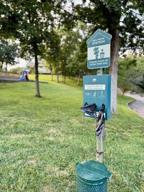 A dog waste station with a sign instructing to clean up after your dog. - Boho Flamingo-Pools, Hot Tub, Pet Friendly (Village of Four Seasons)