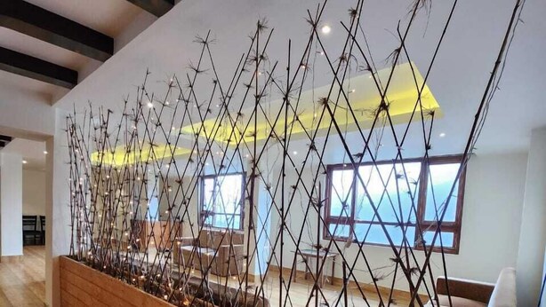 Un interior moderno con un banco de madera y una estructura decorativa en la pared.
