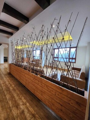 A modern interior with a wooden bench and a decorative wall structure. - THE VEERMAN - BHUMZANG GANGTOK (Gangtok)
