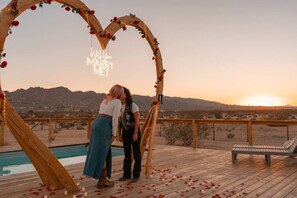 A wooden heart-shaped arch with a neon sign, a pool, and a desert landscape in the background. - The White Owl House ☆pool ☆private ☆gorgeous views (Joshua Tree)