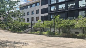 A multi-story building with balconies, a courtyard with benches, and a clear sky. - FeelFree STAYS Antiguo (San Sebastián)