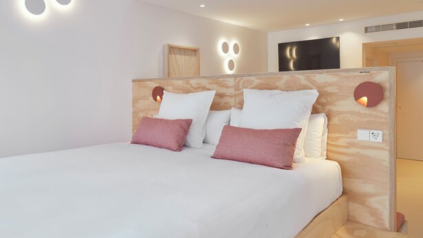 A modern bedroom with a large bed, a wooden headboard, and built-in lighting. - FeelFree STAYS Antiguo (San Sebastián)