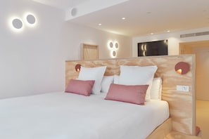 A modern bedroom with a large bed, a wooden headboard, and built-in lighting. - FeelFree STAYS Antiguo (San Sebastián)