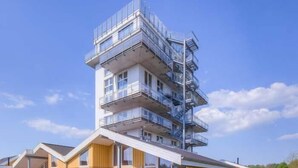 Un edificio moderno de varios pisos con techo plano y balcones.