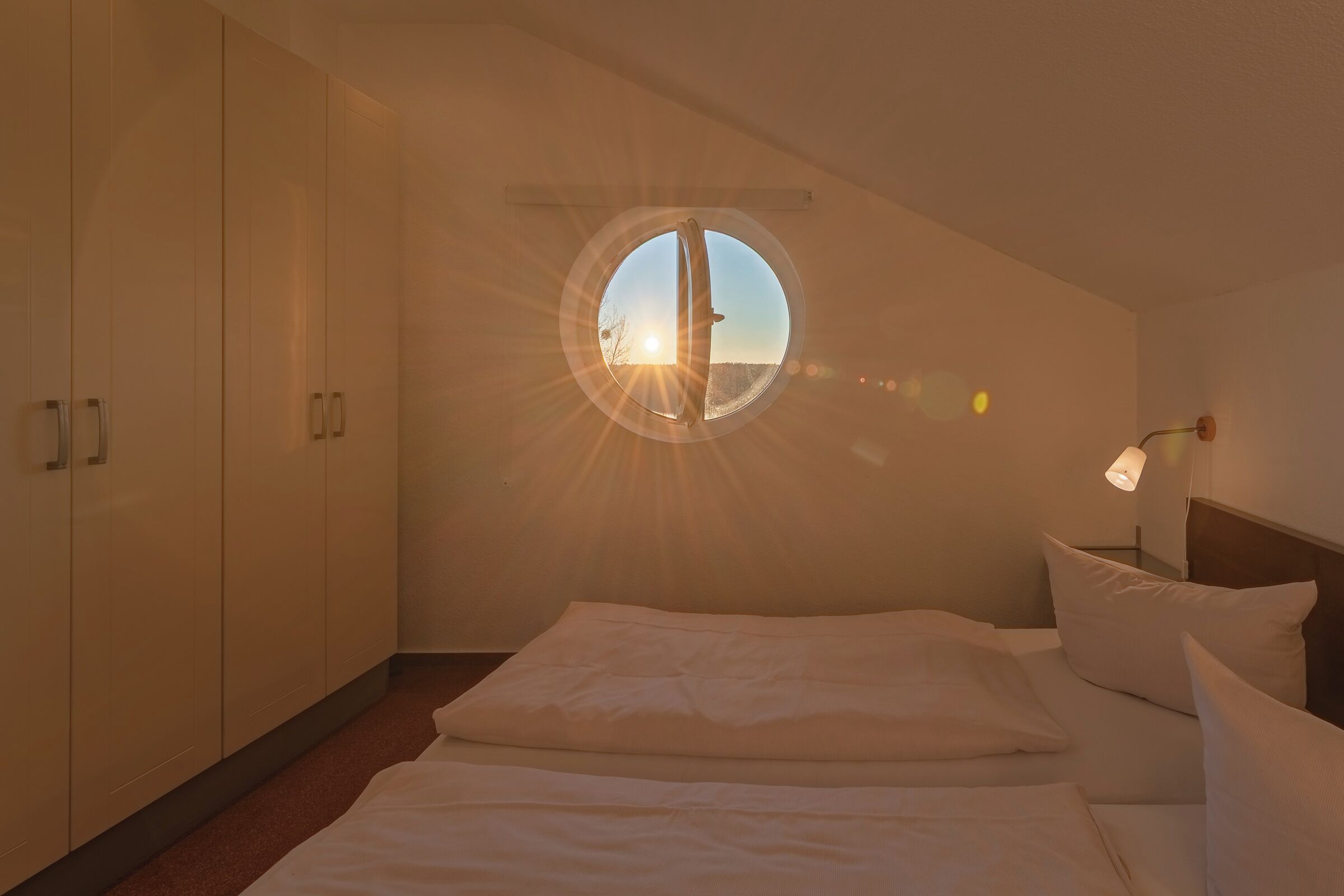 Een slaapkamer met dakraam, een bed en een kledingkast.