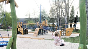 Ein Spielplatz mit Schaukeln und Klettergerüsten.