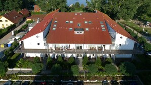 Ein großes Gebäude mit rotem Dach, zahlreichen Fenstern und einem zentralen Eingang.