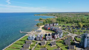 Un quartier résidentiel situé sur la côte, avec des maisons à proximité d’un plan d’eau, et qui présente un mélange d’architecture moderne et traditionnelle.