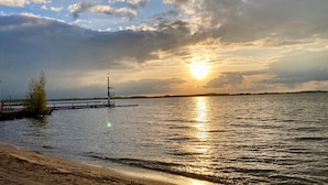A sunset over a calm body of water with a pier extending into the water.