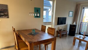 Un comedor con una mesa y sillas de madera, un televisor y una chimenea.