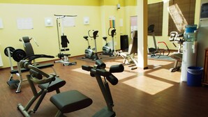 Un gimnasio con equipo de ejercicio variado, incluyendo cintas de correr, bicicletas estáticas y máquinas de pesas.