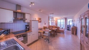 Una cocina moderna con comedor, chimenea y un ventanal que proporciona luz natural.