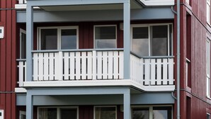 A multi-story residential building with a balcony on the second floor. - Mitteldeck 504 - Cozy vacation apartment with a view of the Müritz (Rechlin-Nord)
