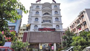 A multi-story hotel with a central entrance, balconies, and a signboard. - Hotel Kolkata (Barasat)