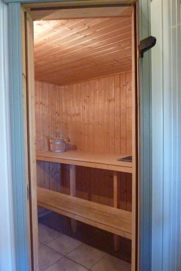 A wooden sauna room with a bench and a shelf. - Seeschwalbe Classic 8 - Großzügiges Ferienhaus mit Eigener Sauna und Whirlpool (Rechlin-Nord)