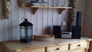 Un mueble de madera con cajones, un pequeño estante con adornos y un estante fijado a la pared con una figurita de pájaro.