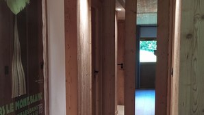 Ein Korridor mit Holzwandverkleidung, einem gerahmten Poster links und einer Tür am Ende.