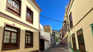 Una estrecha calle adoquinada bordeada por edificios de arquitectura tradicional, con ventanas y puertas visibles.