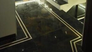 A modern staircase with a reflective surface, leading to a higher floor. - Hotel Manoranjan Enclave (Dindori)