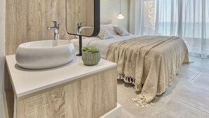 A modern bathroom with a wooden vanity, a large mirror, and a white sink.
