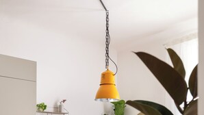 A dining area with a wooden table, white chairs, a yellow pendant light, and a potted plant. - Elegant apartment for 5, DUOMO in 10" by subway M3 (Milano)