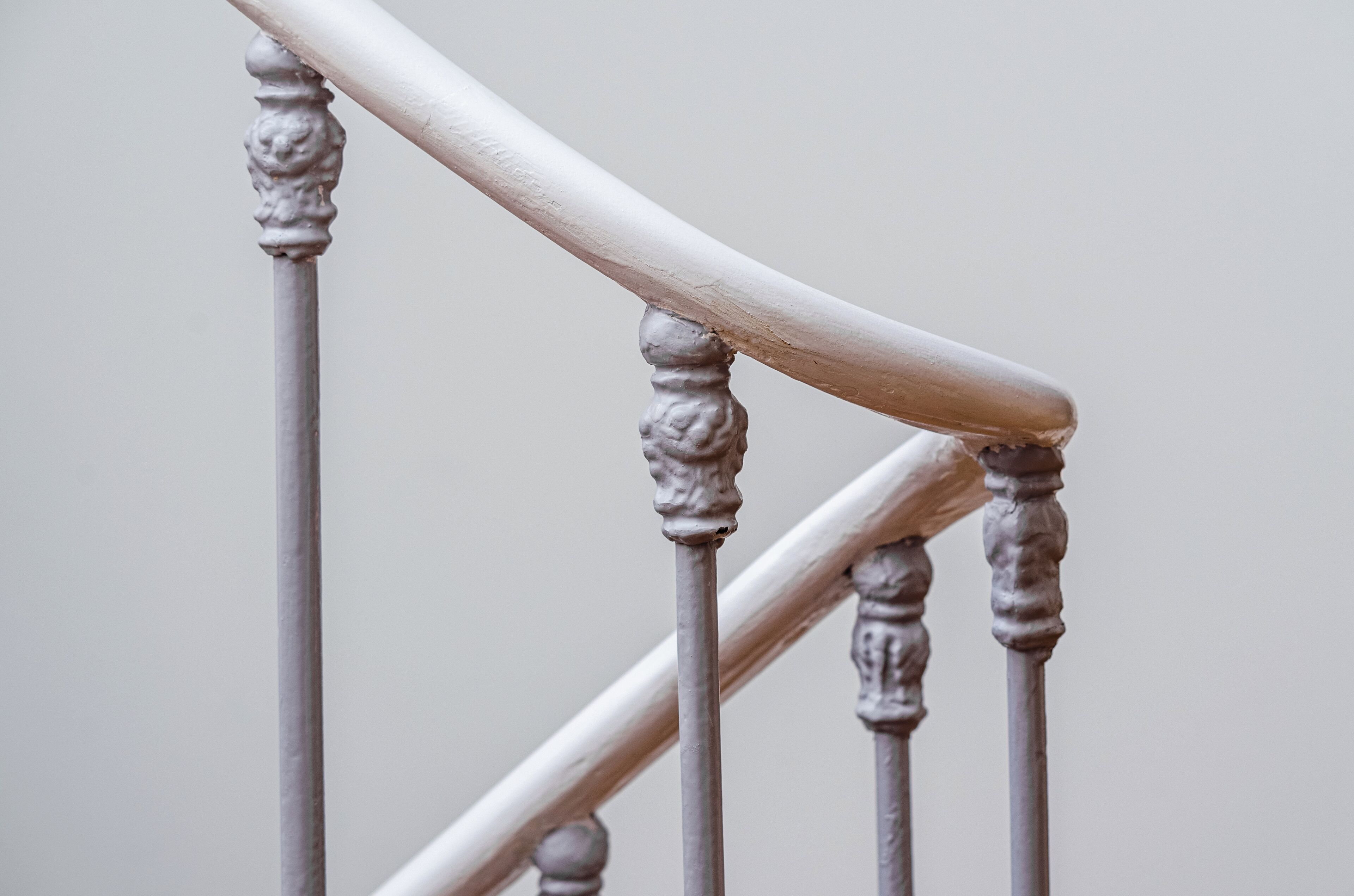 A close-up of a staircase with ornate balusters and a handrail.