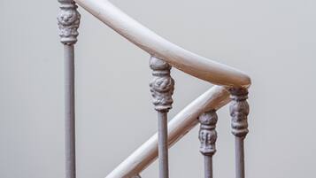 A close-up of a staircase with ornate balusters and a handrail.