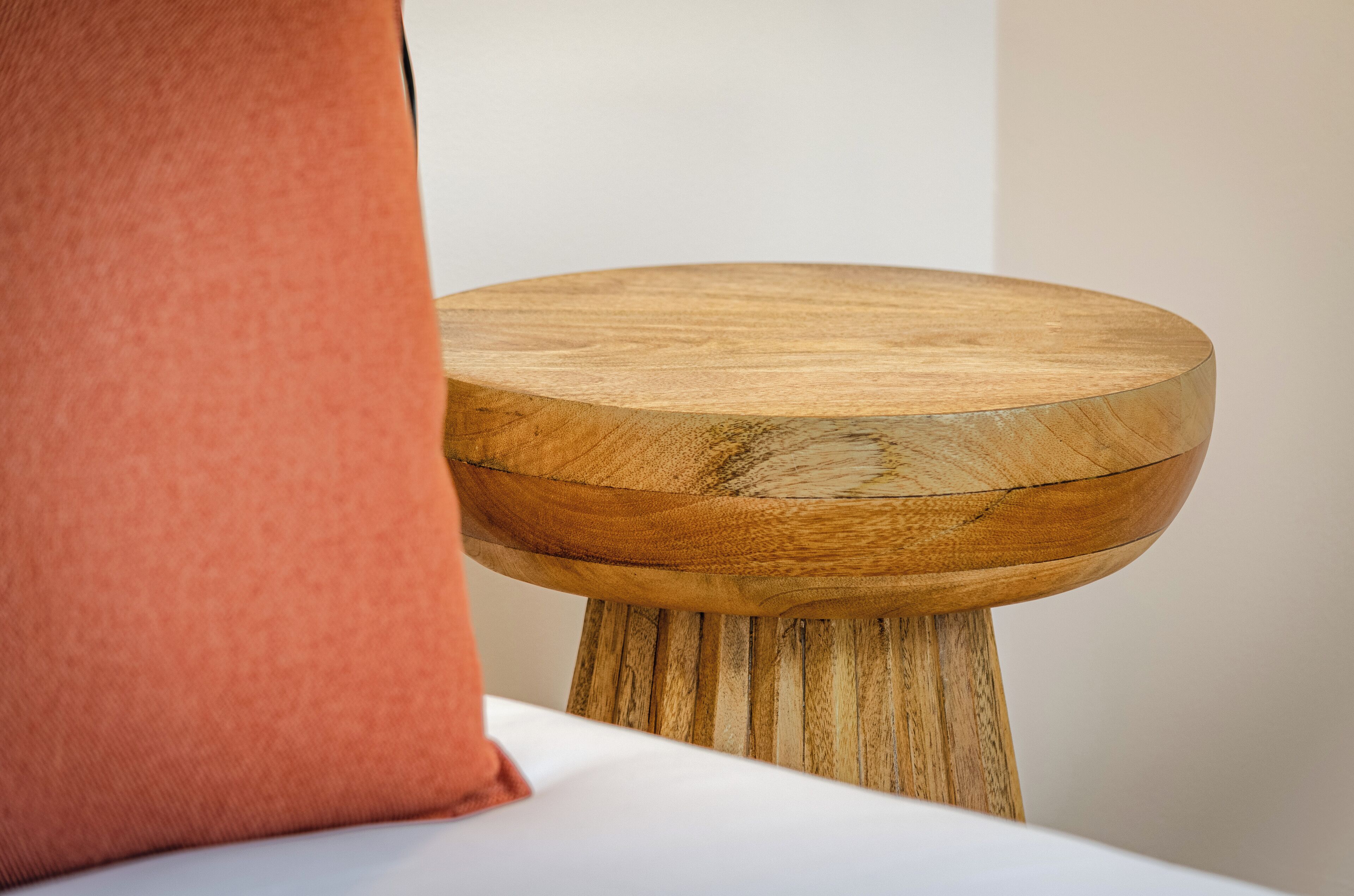 A wooden table with a natural finish, placed on a white surface.