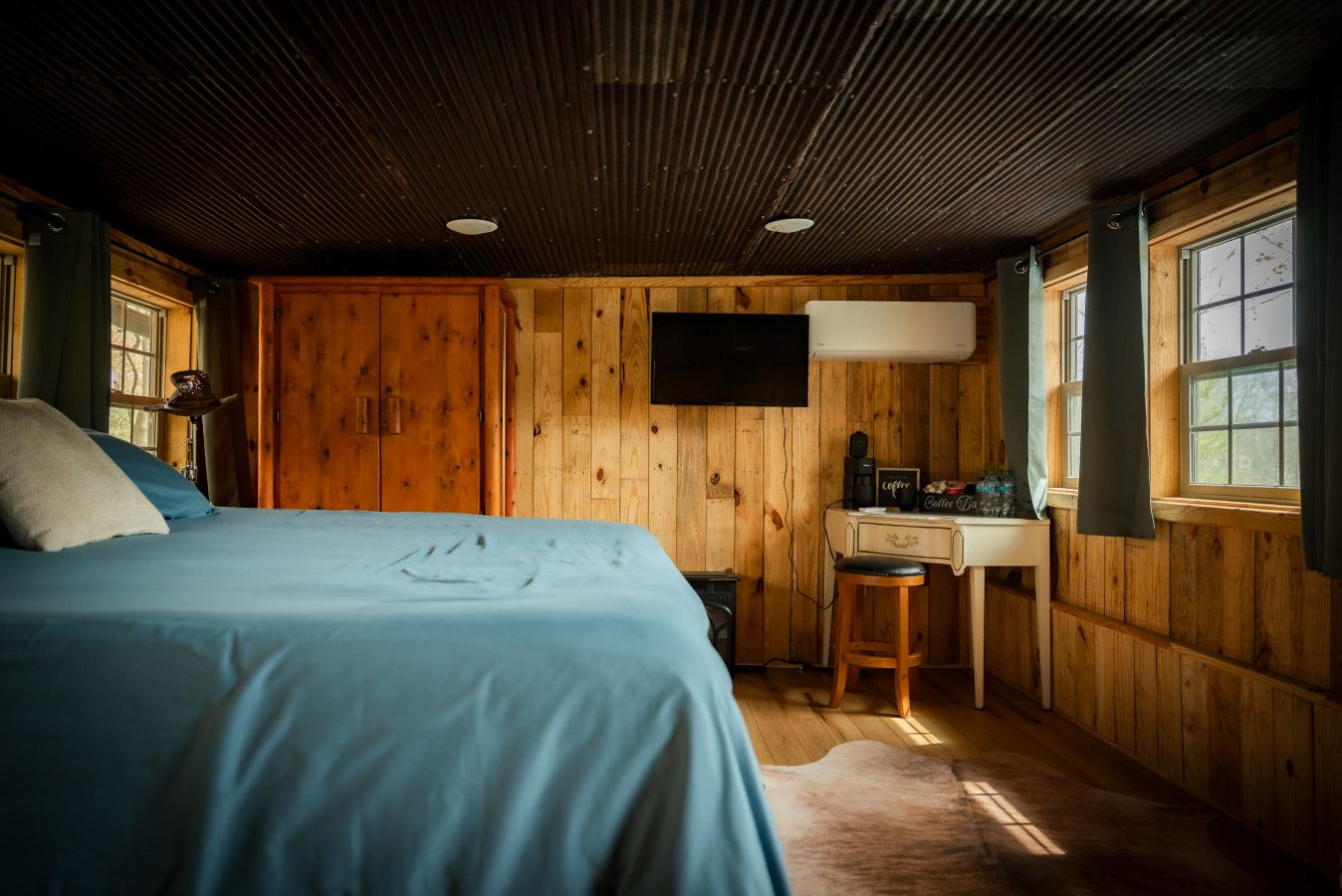 Une chambre confortable avec un lit, un bureau et un téléviseur.