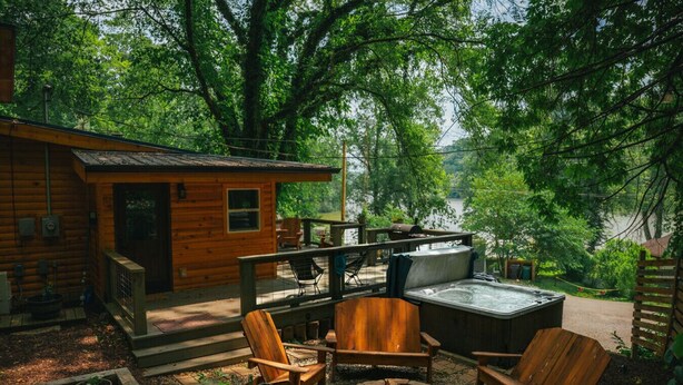 Een chalet met terras, buitenzitplaatsen en een hottub.