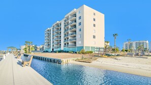 Un hôtel moderne doté de nombreux balcons, d’une piscine et situé en bord de mer.