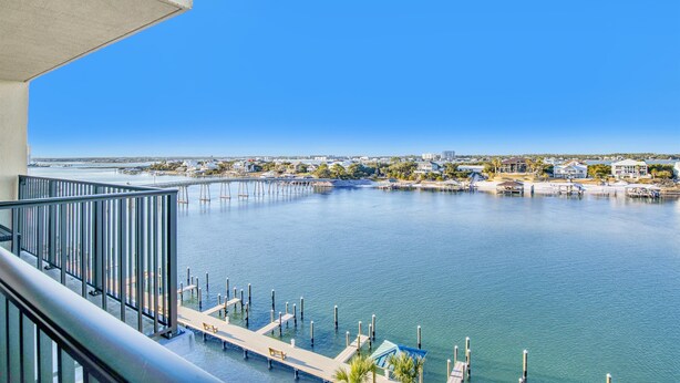 Une vue sur le front de mer depuis un balcon, avec un ciel dégagé, un quai et une marina.