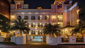 A multi-story hotel with a central entrance, balconies, and a swimming pool. - Sterling Marbella Dehradun (Dehradun)