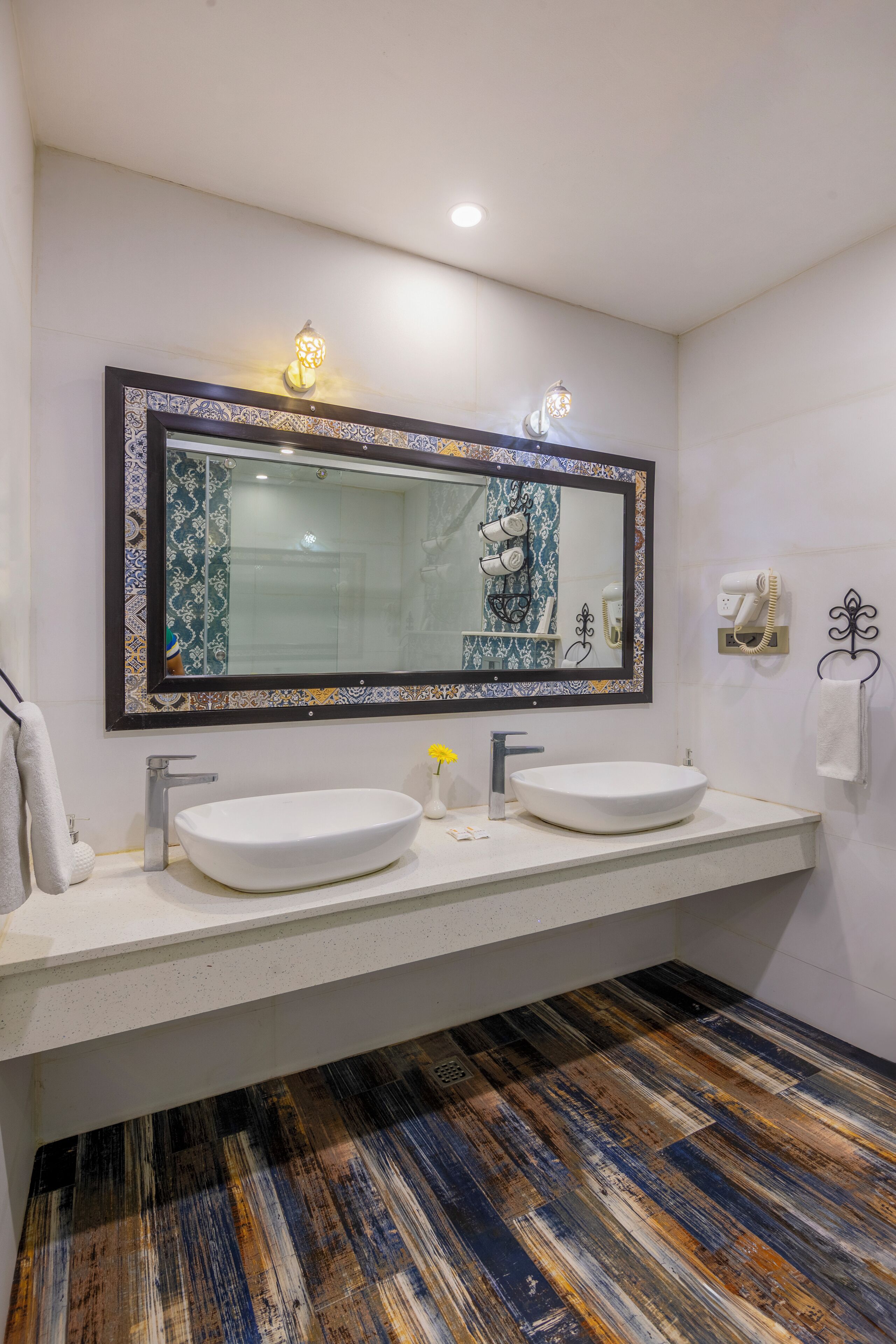 Une salle de bain avec deux lavabos, un grand miroir et un carrelage décoratif.