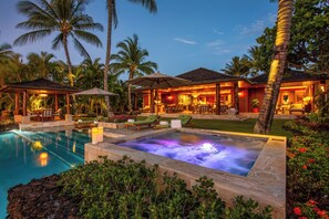 A luxurious resort with a hot tub, outdoor seating, and a swimming pool.
