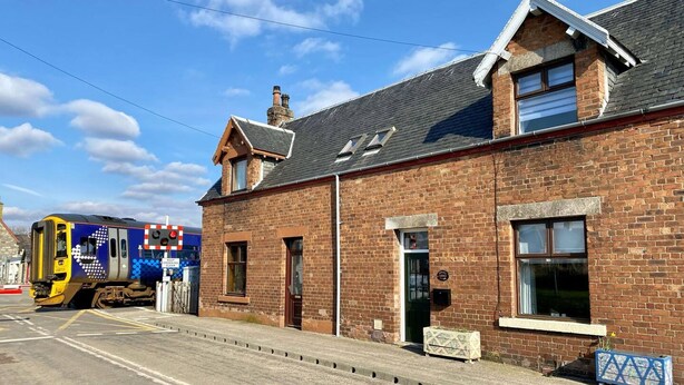 A brick building with a traditional design, a visible door, and a small window. - Crossing Cottage Brora (Brora)