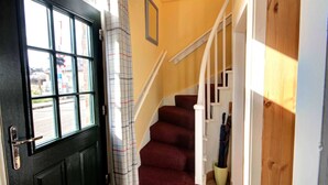 A staircase with a handrail, a door with a window, and a curtain. - Crossing Cottage Brora (Brora)
