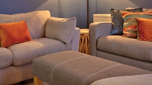 A living room with two sofas, a floor lamp, and a framed picture on the wall. - Otago Cottage Brora (Brora)