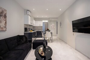 Appartamento Deluxe, patio, vista città | Area soggiorno | TV a schermo piatto